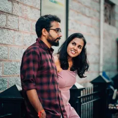 A playful glance from the woman as her partner looks on, captured during a casual street-style photoshoot.