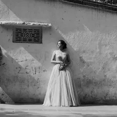 A timeless black and white composition. The play of harsh sunlight and shadow on the wall adds a dramatic, artistic feel to this urban couple's portrait.