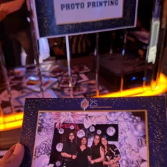 A live photo printing booth in action. This is a fantastic party favor, allowing guests to take home a branded, printed memory from the event instantly.