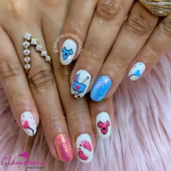 A sweet and celebratory set for a baby shower, featuring hand-painted baby clothes, footprints, and a stroller in pink and blue, with glittery accent nails.