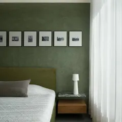We aimed for visual softness in this master bedroom, using warm oak for the corner wardrobe with fluted glass. Paired with textured granite floors and a simple woven bench, the room feels calm and meditative.