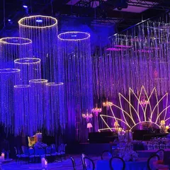This view shows the hanging crystal chandeliers and the floating rings of light that added another layer to the celestial theme. The stage features a neon lotus backdrop, tying the whole design together.
