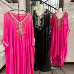 A trio of elegant kaftans in fuchsia and black, all featuring a distinctive scalloped and embroidered neckline.