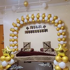 A classic balloon arch in an elegant gold and white color scheme for a retirement party. This setup provides a beautiful backdrop for photos and honors the retiree's contributions in a simple yet festive way.