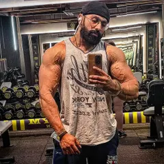 A gym selfie showing a pumped physique. My coaching helps you achieve this look, where your muscles are full and your arms are vascular, reflecting serious training.