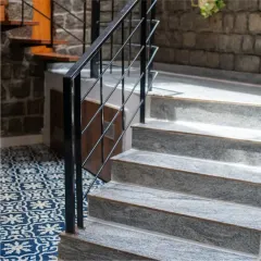 At the Gifty Residence, a combination of granite steps, patterned floor tiles, and an exposed stone wall creates a rich tapestry of textures right at the entrance, welcoming you into the home.