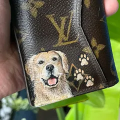 A close-up of another custom LV wallet, this time featuring a happy golden retriever and tiny paw prints. I use specialized paints to ensure the artwork is durable and lasts.