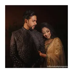 A quiet, romantic moment between the couple amidst the celebration, showcasing their elegant gold and black reception outfits.