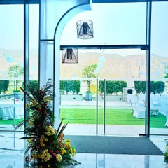 An example of our indoor decor details. This modern archway with hanging cage lamps perfectly frames the view of the outdoor lawn, seamlessly connecting the indoor and outdoor spaces of the venue.