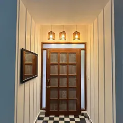 I believe a home's entrance should make a timeless first impression. Here, I transformed a simple entryway with classic checkerboard flooring, custom wall paneling, and a beautiful wooden door, creating a passage that is both elegant and welcoming.