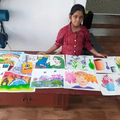 Rishita, a 4th grader, with a collection of her artworks. She has explored watercolours, oil pastels, and poster colours to create a variety of paintings, from landscapes to portraits.