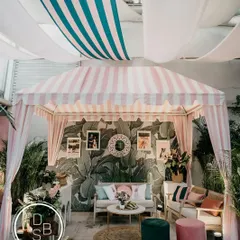 A wider shot of the cabana, showing how the ceiling drapes and lighting work together to create an intimate and stylish atmosphere for the post-wedding brunch.