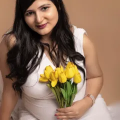 A soft and intimate close-up portrait. Holding a bouquet of yellow tulips, this mother-to-be radiates warmth and joy, showing how simple props can add a personal touch to your photos.