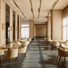 Another perspective of the banquet hall, showing the arrangement of dining tables and the clean, contemporary design with a neutral color palette and dark marble flooring.