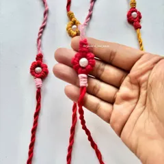 A closer look at the handmade Rakhi, showing the detail of the flower knot and the soft, twisted cotton threads that are gentle on the wrist.