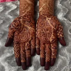 A fresh stain on the palms. The color is deepest here, showing off the detailed paisley and floral work. The fingertips are traditionally capped for the darkest possible stain.