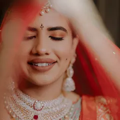 A beautifully artistic shot of a bride on her wedding day. The soft, warm tones on her eyes and the natural lip color create a look of pure, serene happiness.