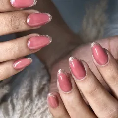A classic look with a touch of sparkle. This design features a soft pink base with a delicate silver glitter French tip, offering an elegant and glamorous update to the traditional French manicure.