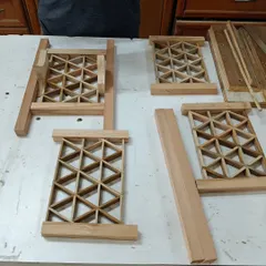 The components of a triangle grid Kumiko lamp laid out before assembly. This pattern, known as 'mitsukude,' creates a strong and visually complex design.