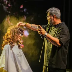 In the zone, adding the final touches on stage. This shot captures the energy of a live demonstration, where I use products like hairspray to lock in the texture and volume of these defined curls for the Schwarzkopf Lived-In Show.