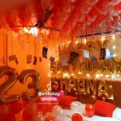 A vibrant and personalized 23rd birthday room decoration. The setup includes a ceiling full of red and white balloons, foil number balloons for the age, and the birthday girl's name spelled out in gold letters.