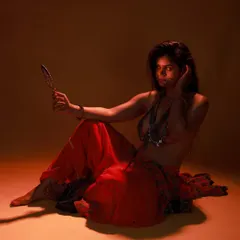 This is an example of a low-key, moody studio shoot. Using a single light source and a prop mirror, we created a mysterious and artistic portrait with deep shadows and a warm, orange glow.