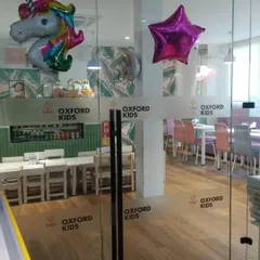 The glass entrance to our cafe, decorated with unicorn and star balloons for a party.