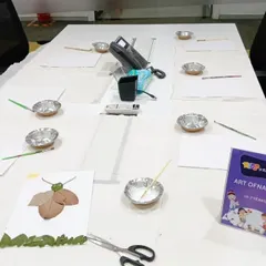 An "Art of Nature" workshop set up in an office space. We bring all the supplies, from leaves and twigs to paper and glue, for a creative session where kids make art from natural materials.