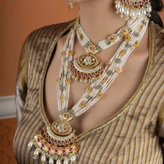 A closer look at the drape of our layered pearl and Kundan rani haar. The intricate pendants and detailed beadwork are hallmarks of our bridal collection, designed to complement traditional Indian wedding attire.