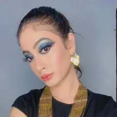 A beautiful example of a glamour fashion look. The focus here is on the dramatic blue and gold winged eyeshadow, paired with a clean base and a soft pink lip to balance the look.