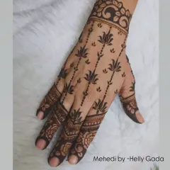 This elegant back-hand design features delicate lotus stems that appear to grow up the hand. It's a beautiful, nature-inspired look that is both graceful and modern.