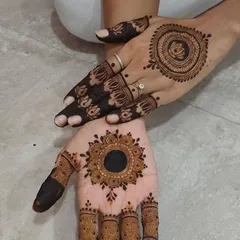 A combination of two different styles on each hand, one with a lotus mandala and the other with a sun mandala.