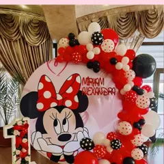 A classic Minnie Mouse theme on a circular backdrop, with red, white, and black polka-dot balloons.