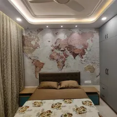 This angle highlights the room's thoughtful lighting design and storage solutions. The ceiling spotlights are positioned to perfectly illuminate the map, while the expansive grey wardrobe offers a clean, seamless look that conceals extensive storage space.
