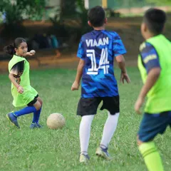 A young girl confidently dribbles the ball during a training match. We are committed to developing female footballers and providing equal opportunities.