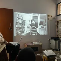 An artist talk in progress, with an image projected on the wall for discussion. These sessions provide a platform for creators to share their work and receive feedback from their peers.