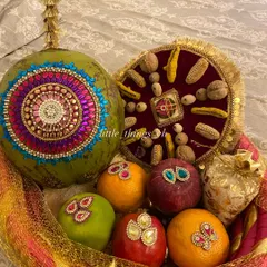 This is our modern take on the traditional 'Oti' blessing basket. It features a coconut decorated with intricate kundan work, alongside embellished fruits, all arranged to bring blessings of prosperity and abundance to the mom-to-be or new bride.
