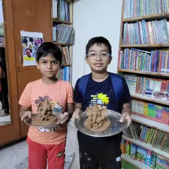 Two boys proudly display their finished Ganesha idols. This activity is a beautiful blend of art, culture, and community.