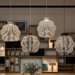 A grouping of four wooden pendants, showcasing the different finishes available. These lamps are designed to last for generations and are made from premium, renewable birch.