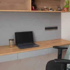 A close-up of the floating desk, showing the clean lines and seamless integration of power outlets. It’s a space designed for focus and productivity.