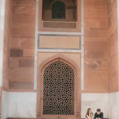 A couple sharing a quiet moment against the magnificent architecture of Humayun's Tomb. This kind of environmental portrait tells a story about both the people and the place.