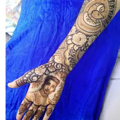 This full-arm design features a custom portrait of the groom, surrounded by intricate floral and peacock motifs. It's a beautiful way to include a loved one in your henna design.