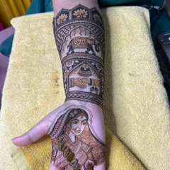 A close-up of a bride's hand with a portrait of her, complemented by the groom's hand with a matching design.