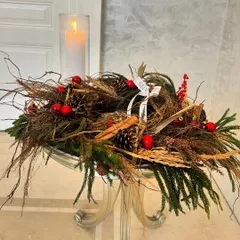 Pines, berries, and twigs create a rustic Christmas feel. This centerpiece, paired with a glowing candle, is perfect for a coffee table or console, bringing a cozy and charming woodland vibe to your decor.