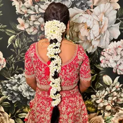 A traditional South Indian bridal braid, heavily adorned with fragrant jasmine flowers (mogra). This is a classic and timeless look for a wedding ceremony.