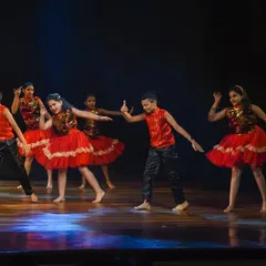 A group of young dancers executes a synchronized move, highlighting the teamwork and discipline we foster. Their coordinated outfits and confident poses make for a polished stage presentation.