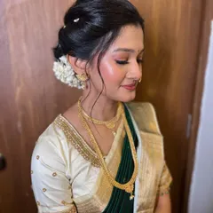 A serene portrait of the bride. Her eyes are closed, showing off the soft, shimmery eyeshadow that complements her traditional attire.