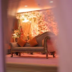 A glimpse of the engagement stage from the side, showing how the elements come together. The soft, warm lighting enhances the floral wall and creates an intimate and inviting atmosphere for the ceremony.