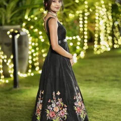 A side profile of the black floral embroidered gown, showing its elegant silhouette and the beautiful drape of the raw silk.