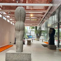 Another view of a Stephen Cox sculpture, where the texture of the stone interacts with the light and the architectural materials of the museum. This interplay between art and its container is central to the design.